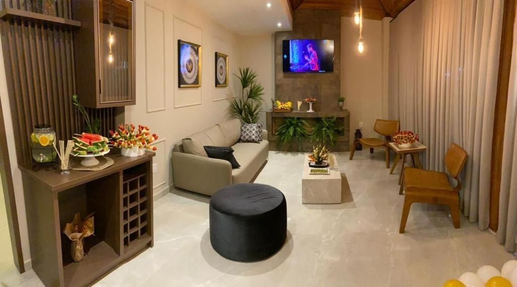 Sala de estar do Hotel Lorimar com sofá, poltronas, TV e decoração acolhedora