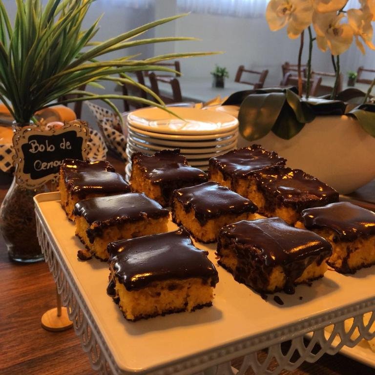 Bolo de cenoura com cobertura de chocolate fatiado em uma bandeja branca