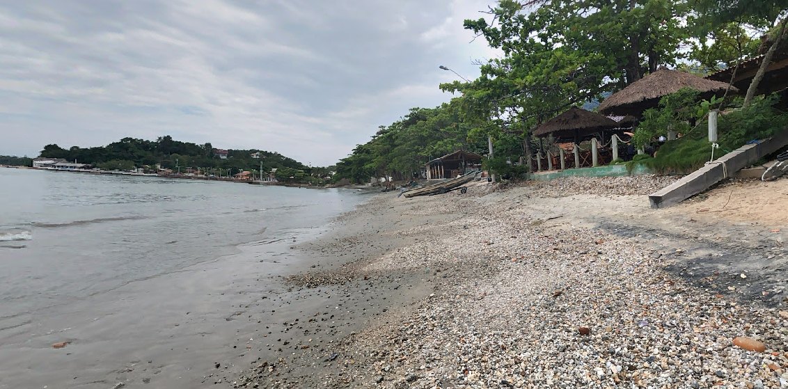 Praia do Manguinho, em Penha, praia tranquila de águas calmas com quiosques de palha à beira da areia