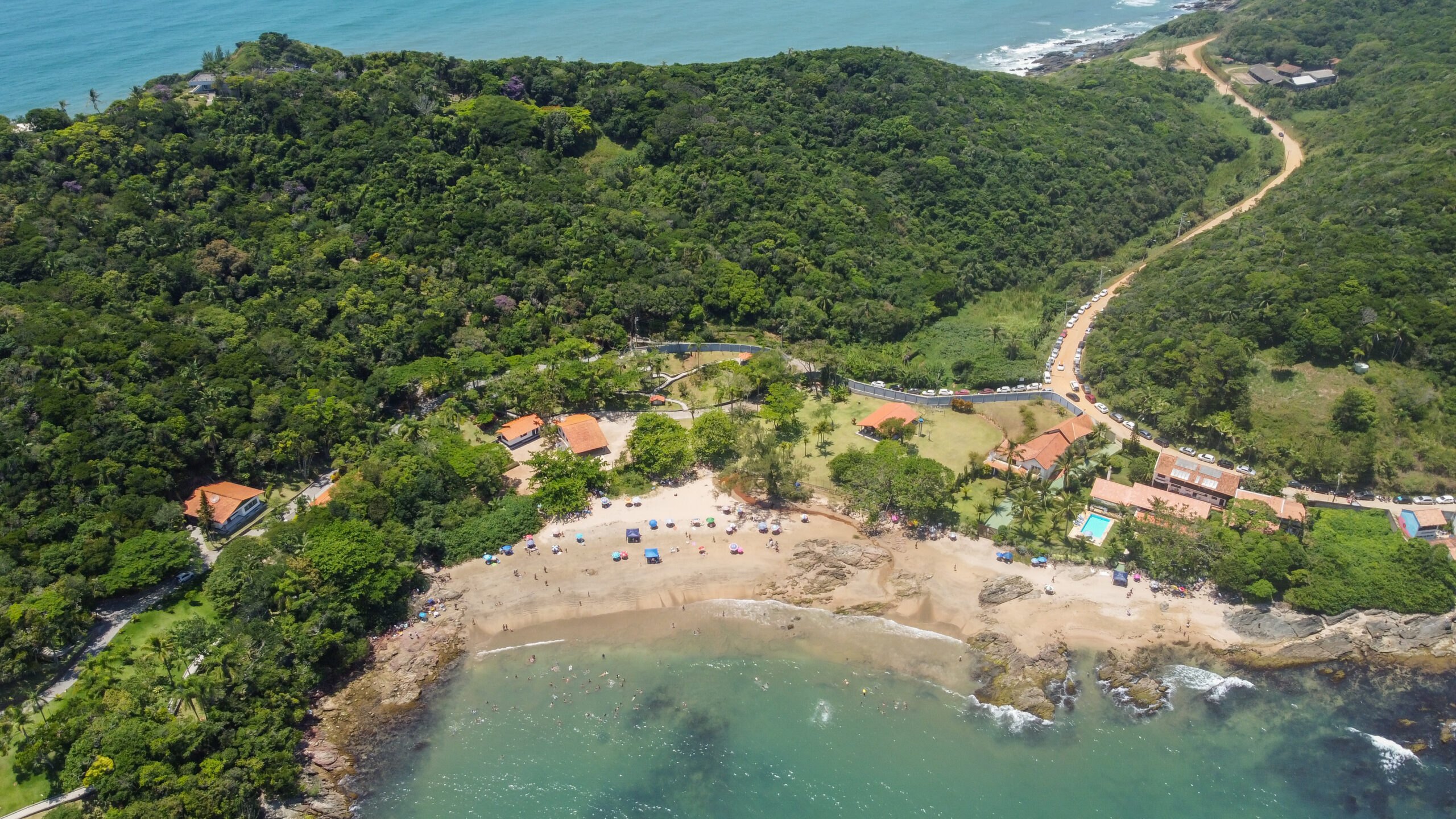 Vista aérea da Praia do Monge, em Penha, uma enseada recolhida entre morros de mata atlântica
