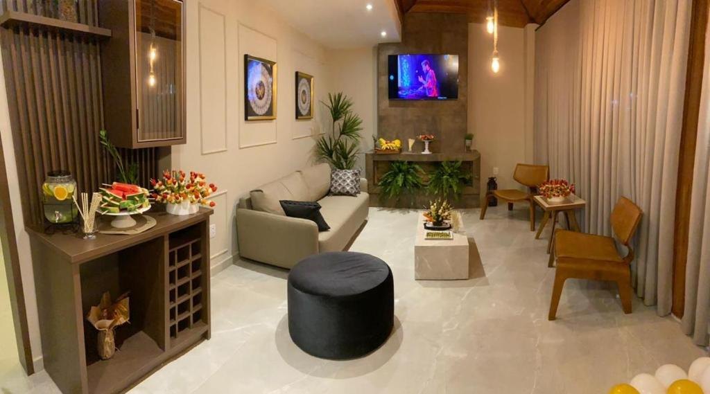 Sala de estar do Hotel Lorimar com sofá, poltronas, TV e decoração acolhedora